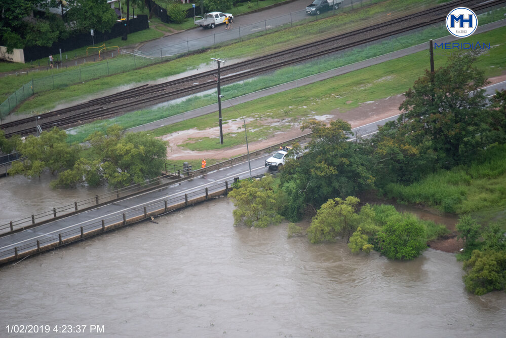 Road Worker Inspects Rooney's Bridge, aerial photograph during floods, 2019. 