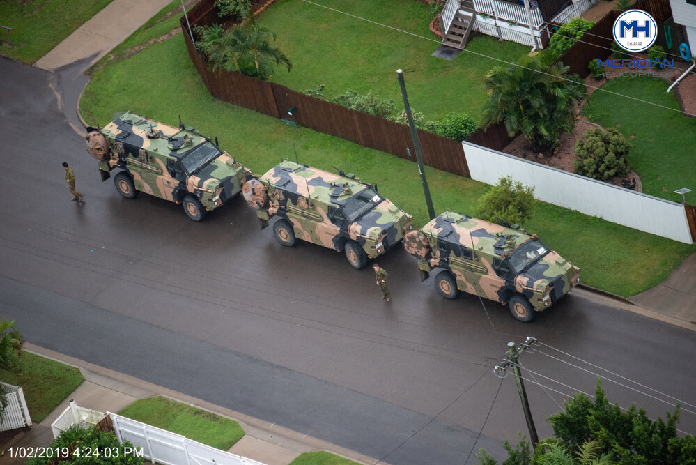 Army vehicles corral on residential street, aerial photograph during floods, 2019. 