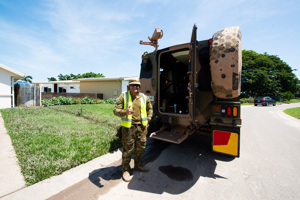 Army volunteer poses in front of vehicle, 2019.