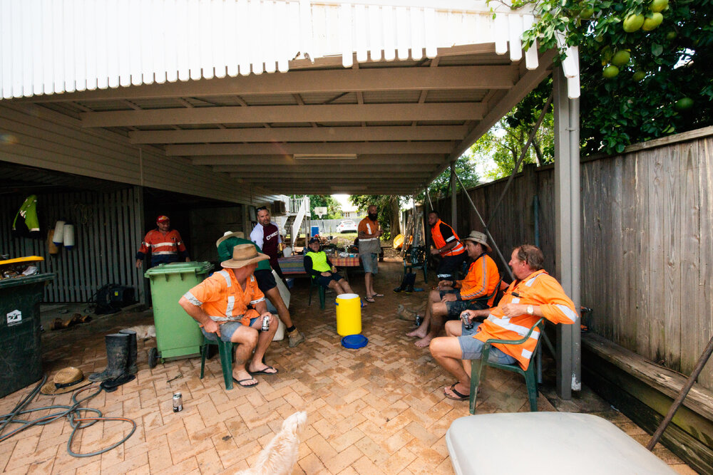 Residents/Volunteers sitting in group with beers at flood affected property, Hermit Park, 2019