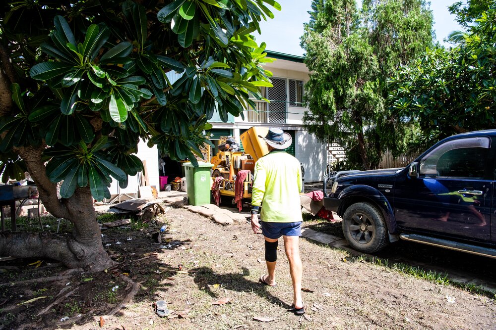 Flood affected property with damaged contents on footpath, Resident/Volunteer in driveway, Hermit Park, 2019