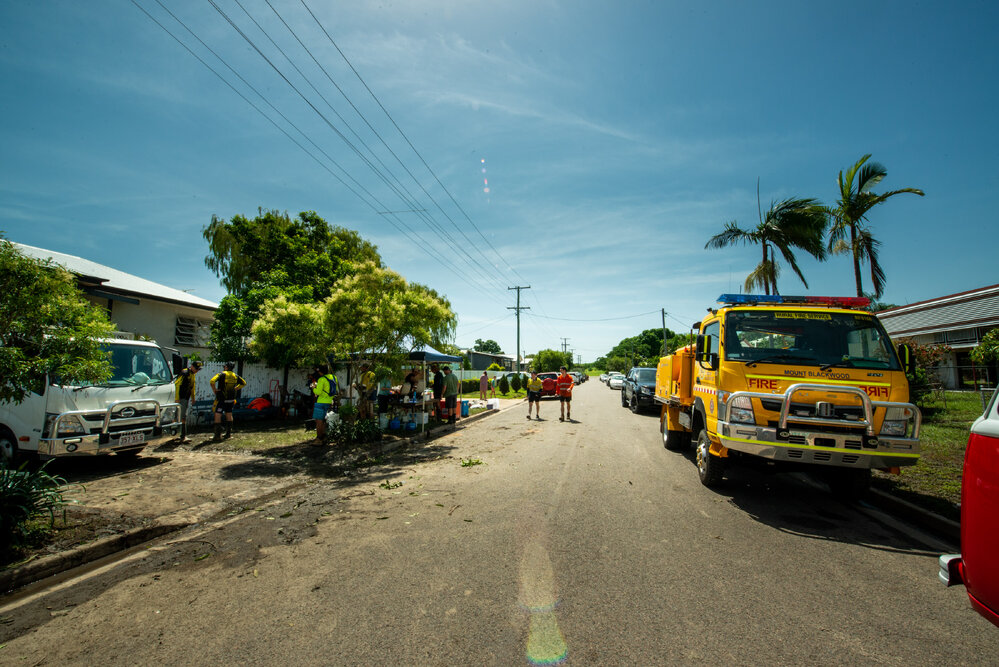 Community food tent with Residents/Volunteers collecting food and drink, SES Vehicle parked on street, Hermit Park, 2019