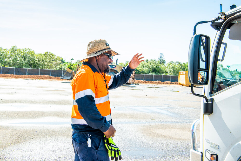 Staff member driving excavator at Lou Lister Park temporary transfer station, Hermit Park, 2019.