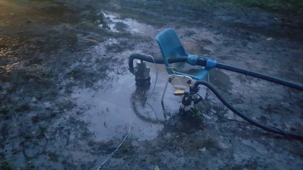 Flooded backyard with impromptu pump system, McIlwraith Street, South Townsville, 2019.