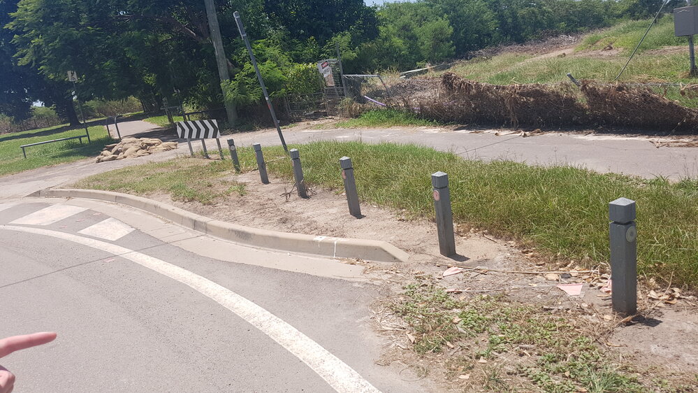Sand bags piled on the footpath and fence collapsed from flood water flow, Rosslea, 2019. 