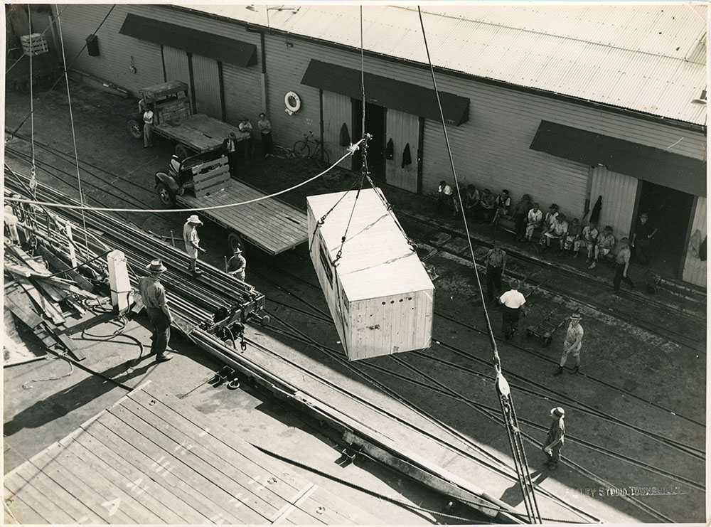 McDonald collection : Austin A70 Somerset cars in shipping crates being unloaded from the ship Treloske in Townsville harbour, ca.1953