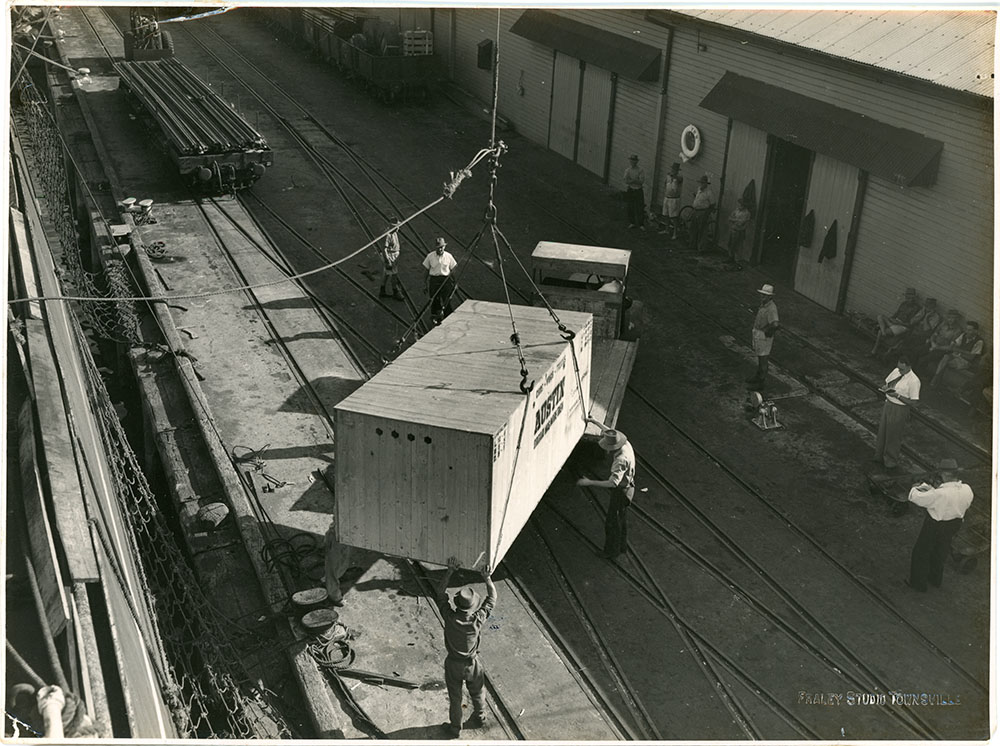 McDonald collection : Austin A70 Somerset cars in shipping crates being unloaded from the ship Treloske in Townsville harbour, ca.1953