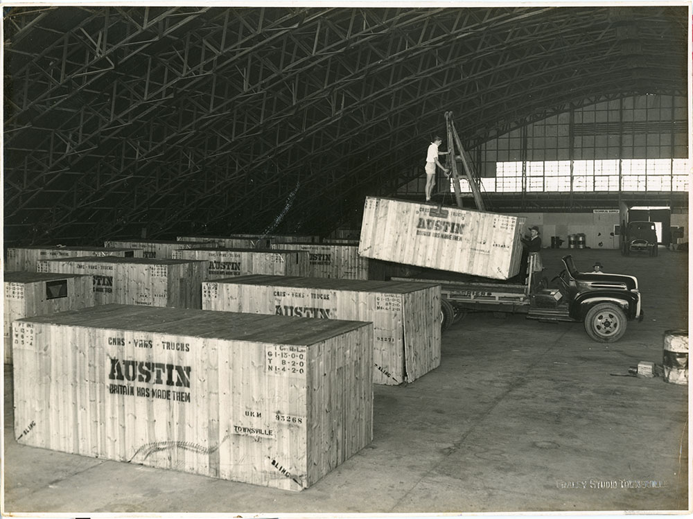 McDonald collection : Austin A70 Somerset cars imported by McDonald Brothers being unloaded for assembly in the hangar at Mount Louisa, Townsville, ca.1953
