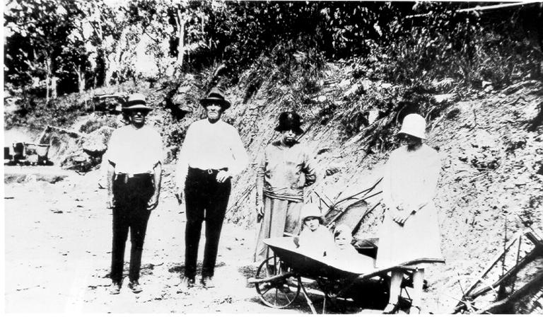 Mount Spec, road construction works visited by Mr and Mrs Casey and Mr and Mrs Barney with children in wheelbarrow, ca 1930 