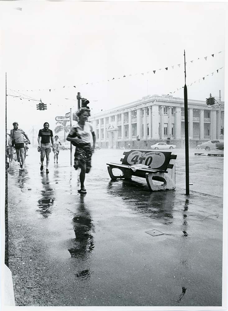 Pedestrians caught in a storm, Flinders Street, Townsville, 17th January, 1976