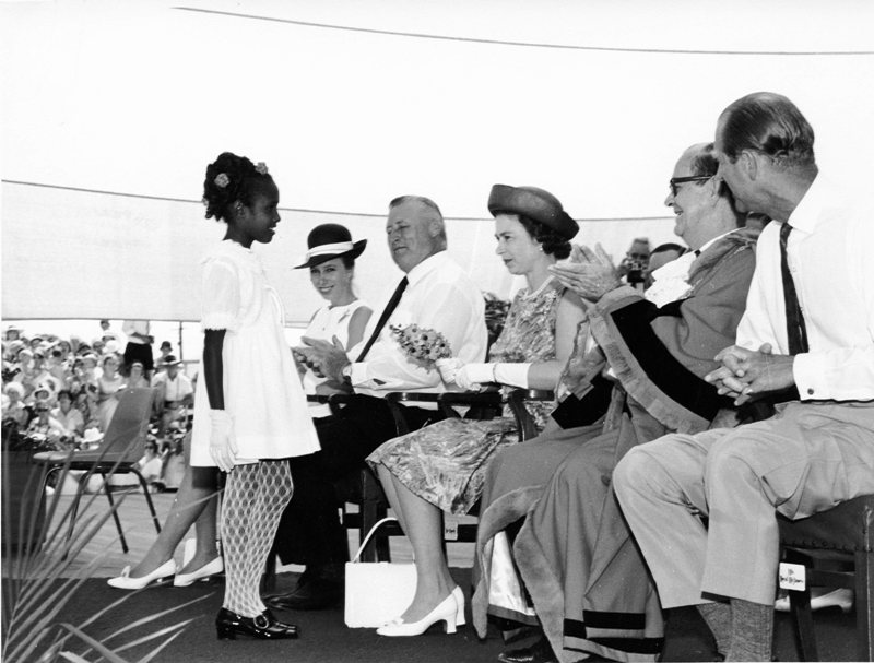 A young girl presents flowers to Queen Elizabeth at the Townsville Sports Reserve 