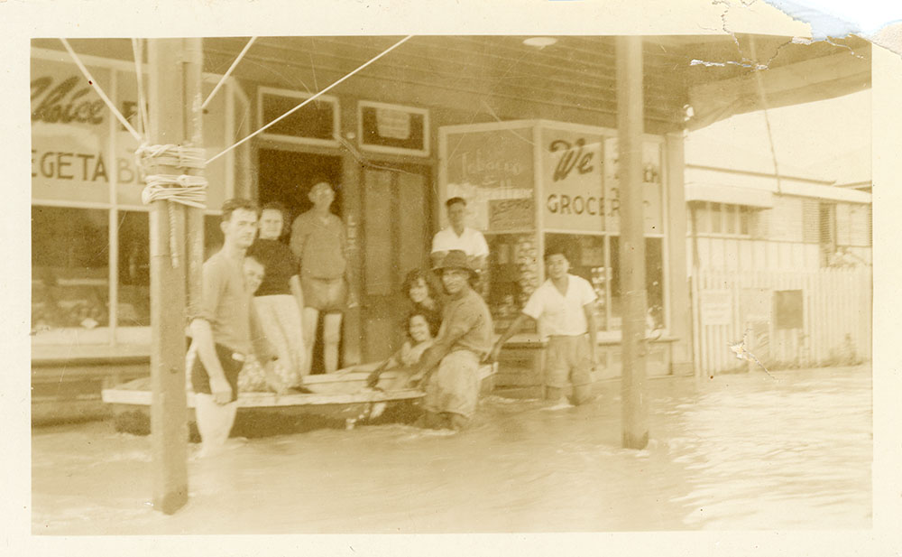 Townsville residents standing in floodwater in front of Philip Leong's store during the 1946 Townsville flood