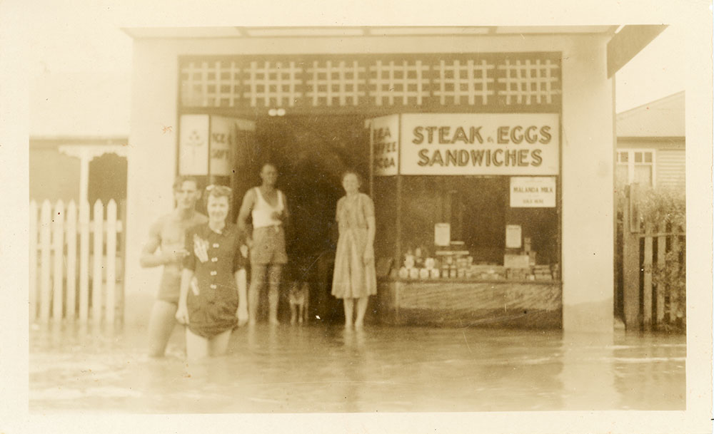 Townsville residents standing in floodwater in front of a cafe during the 1946 Townsville flood