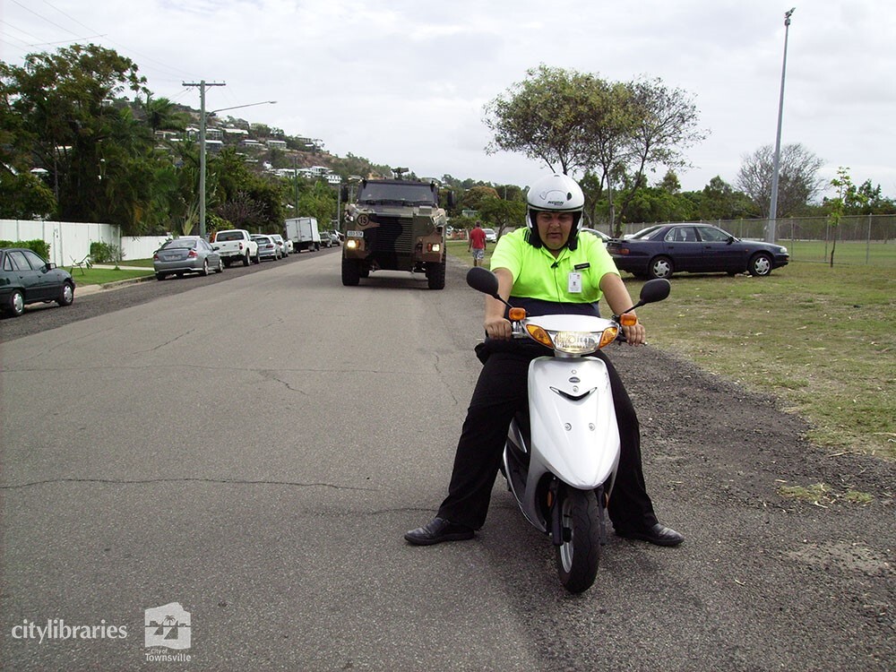 Volunteer marshall in front of army vehicle in the Tropigo Carnival parade at Cultural Fest, The Strand, Townsville, 18 August 2007