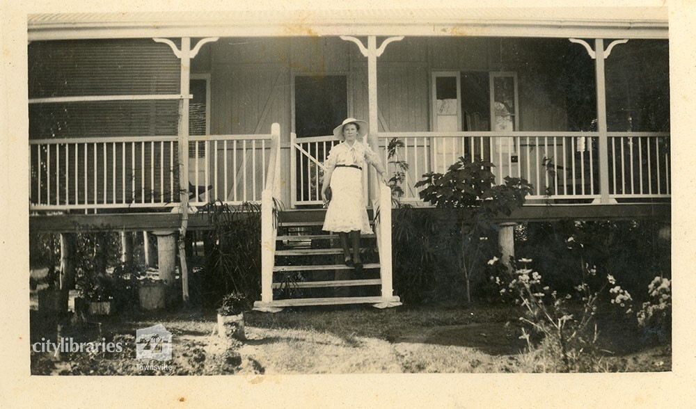 Person on the front steps of a house, 1935