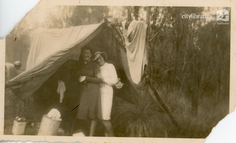 Two people posing at the entrance to a tent, 1940
