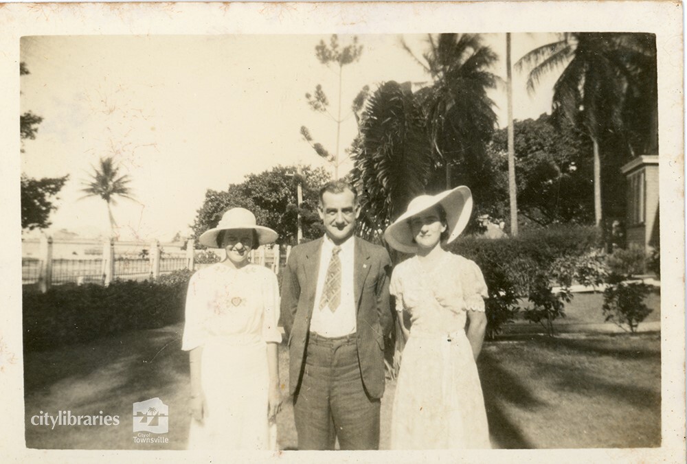 Three people posing in gardens, Townsville, 1946