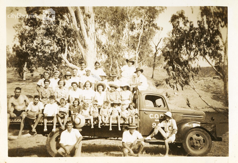 The crowd that went to the C.O.D. picnic posing on the back of a truck, Alice River, Townsville, 1946