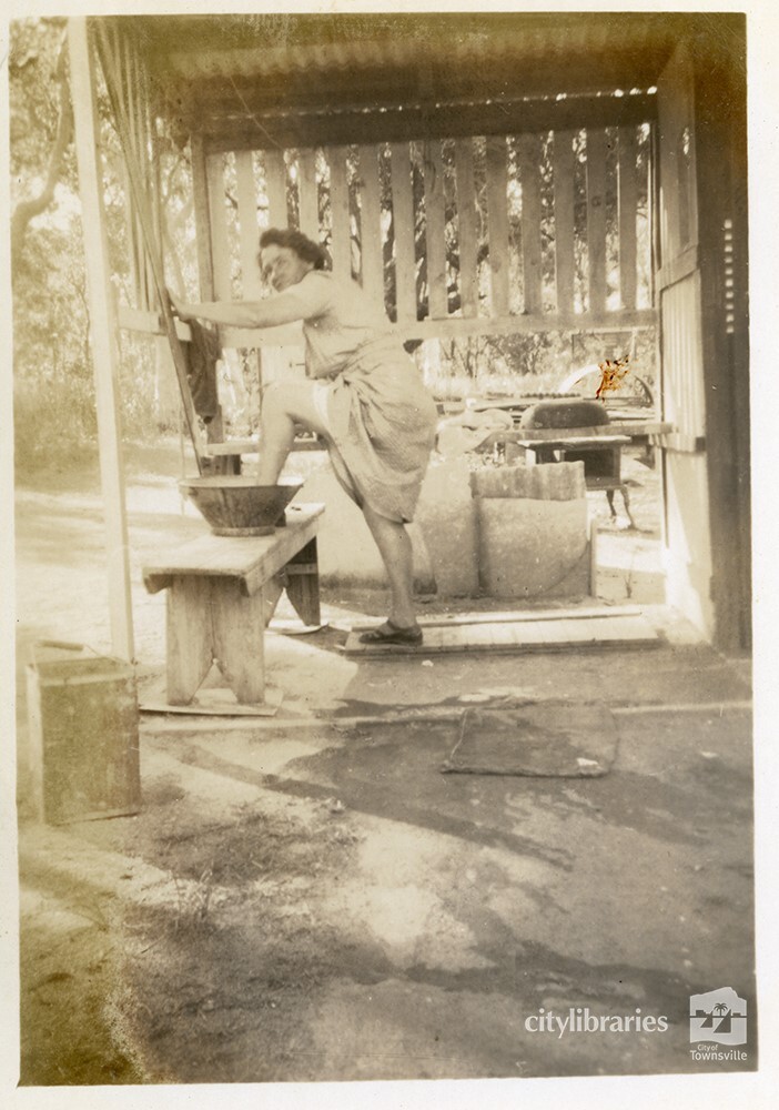 Woman washing her feet in an outdoor basin, [Magnetic Island], Townsville, ca. 1949