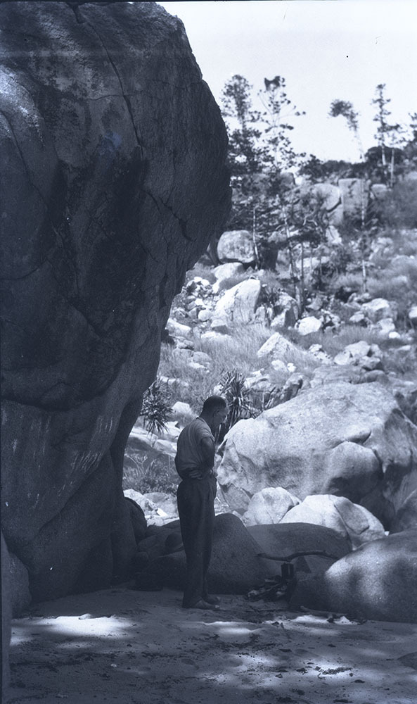 Arthur (Doug) Armstrong standing by a campfire, Alma Bay, Magnetic Island, [between 1908 and 1930].