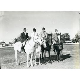 Four equestrians and horses in the centre ring of the Townsville Show, 6 July 1966