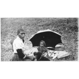 An Australian South Sea Islander woman with her child and pet dog, ca.1900
