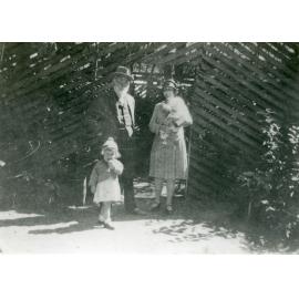 Wm. Anderson and Mrs Brazier holding Keith, and Nancy in front of the Cassowary cage, Queens Gardens, Townsville 1929