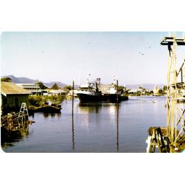 A trawler being assisted by a tug onto the Evans Deakin slipway, Ross Creek, Townsville, December 1978. 