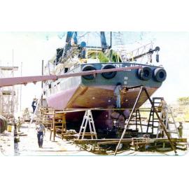 The trawler "Trident Aurora" undergoing emergency repairs on the Evans Deakin slipway, Ross Creek, Townsville, 1979