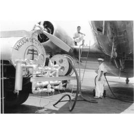 Employees of the Vacuum Oil company refuelling a C47 plane at the Garbutt airport, Townsville. 