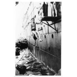 Vincent Parker hanging from the side of a ship. 