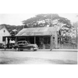 [Motor vehicle parked in front of shop, Townsville]. 