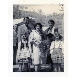 Harold Holt, Minister for Immigration and Mrs Zara Holt pose with children dressed in their national costumes during a visit the Stuart Immigration Holding Centre, Townsville, ca.1952