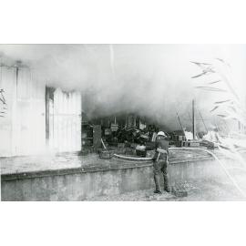 Firefighters attending the fire at the Endeavour Foundation workshop, Landsborough Street, North Ward, Townsville, 27th May, 1974