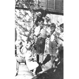 Kelso family children, blowing soap bubbles through paw paw sticks, ca 1919 