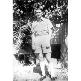 Hughy Gurr standing near mango tree, ca 1930 