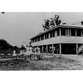 The Aboriginal Roman Catholic Mission School at Palm Island, with Aborigines in foreground, 1940s