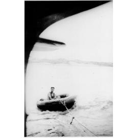 Lorrie Kirk in rubber dinghy, being towed by aircraft, at Redpoint, ca 1940 