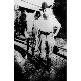 Cyril Benton in borrowed clothes beside horse, ca 1938 