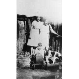 Mrs Hussey and friend with Ernie Hussey in toy car with dog, n.d. 