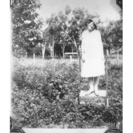 Biddy Neville, standing on box, ca 1925 