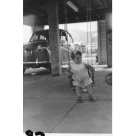 Leanne McIntosh, with car in background, Aitkenvale, 1963 