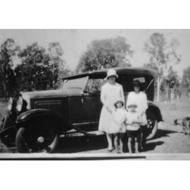 Biddy, Pat, and Frank Neville with Whippet car and dog in background, 1932 