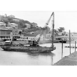 Driving piles for temporary staging in the construction of the George Roberts bridge across Ross Creek, Townsville. 