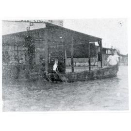 Alfred Lewis and his father with a canoe during the Giru flood, 1940
