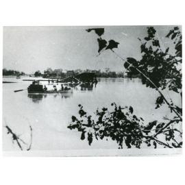 Luggage being rowed across the Burdekin River past the flood destroyed section of the Burdekin River railway bridge, 1922