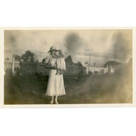 Family photograph from the Quelch Forno collection : Woman and baby posing for a photograph in a garden
