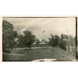 Family photograph from the Quelch Forno collection : Unidentified lowset building with flag