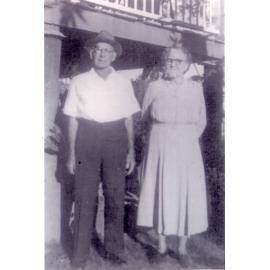 Family photograph from the Quelch Forno collection : Older couple posing for photograph near a highset house, Townsville