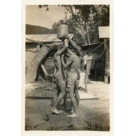 Family photograph from the Quelch Forno collection : Young men using a makeshift shower